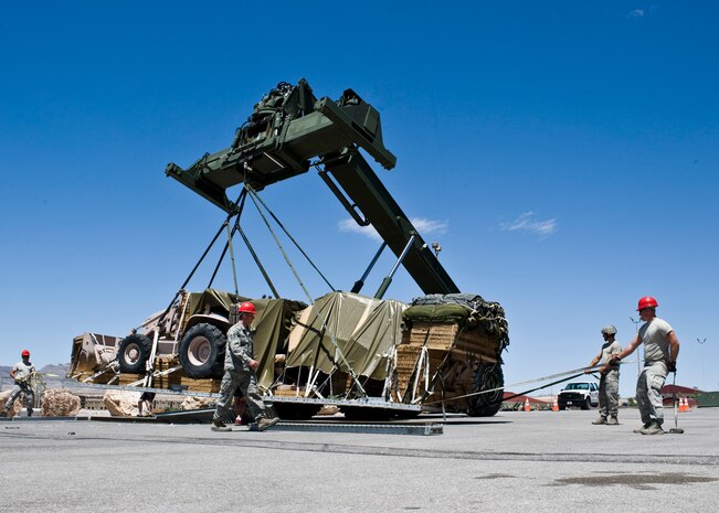 Airmen from the 99th Civil Engineer Squadron airborne flight use heavy machinery to lift cargo May 29, 2013, at Nellis Air Force Base, Nev.  The cargo is being air dropped out of a C-130 Hercules during a Joint Forcible Entry Exercise. The joint airdrop exercise is designed to enhance service cohesiveness between the U.S. Army and Air Force. (U.S. Air Force Photo by Airman 1st Class Jason Couillard)