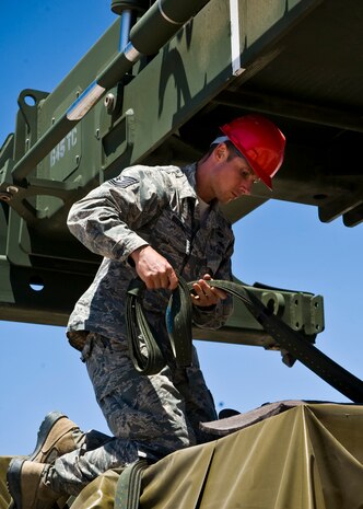 Tech. Sgt. Jason Bischoff, 99th Civil Engineer Squadron NCO in charge of B-Team for RED HORSE Airborne, secures cargo for a Joint Forcible Entry Exercise May 29, 2013, at Nellis Air Force Base, Nev. The 820th RED HORSE squadron is capable of air insertion to repair damaged airfields during contingency and wartime operations. (U.S. Air Force Photo by Airman 1st Class Jason Couillard)