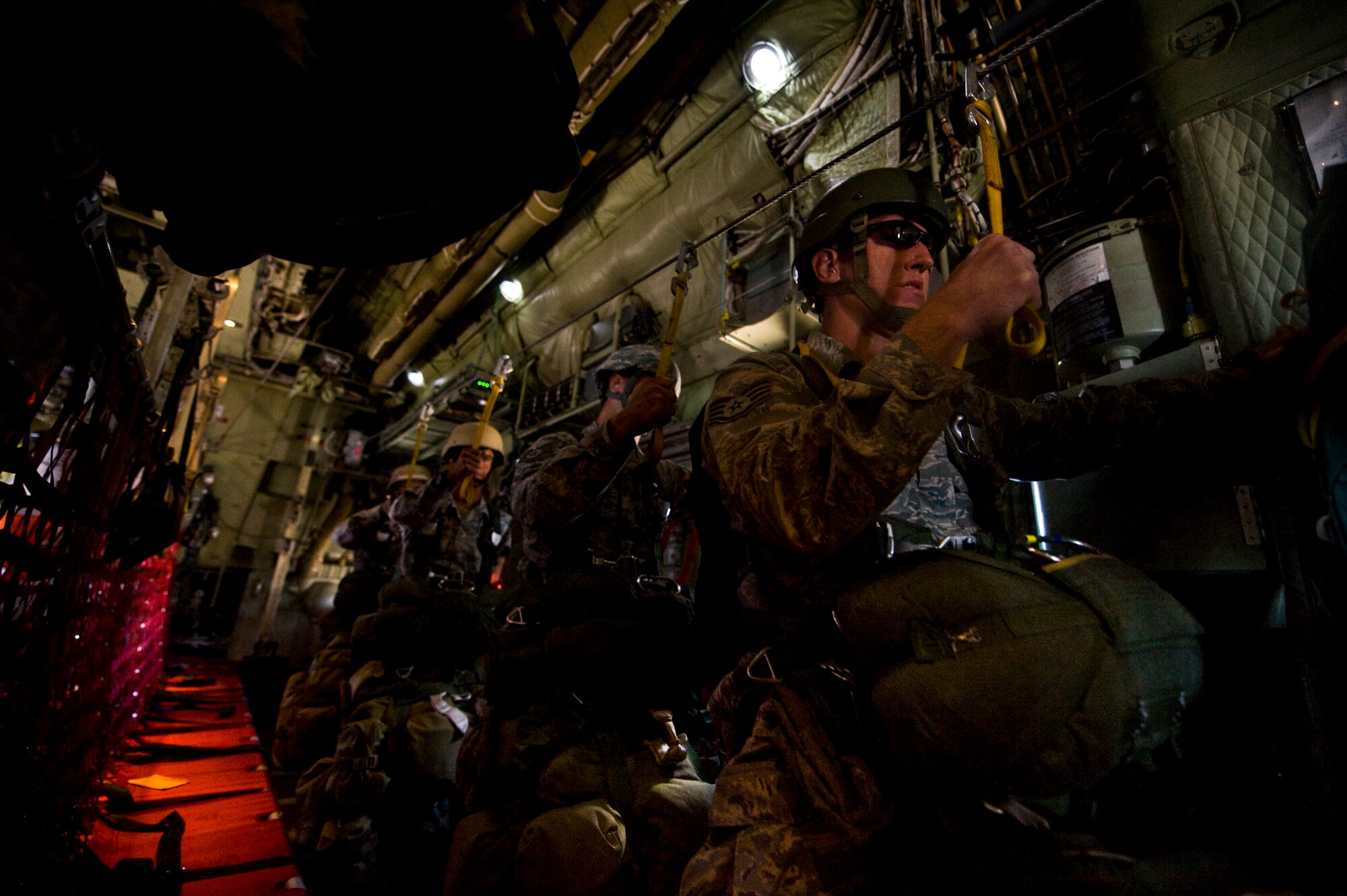 Airmen from the 820th RED HORSE airborne flight prepare to parachute out of a C-130 Hercules during a Joint Forcible Entry Exercise May 31, 2013, at Nellis Air Force Base, Nev. Once on the ground, the airborne engineers will assess and repair any simulated runway damage. (U.S. Air Force Photo by Airman 1st Class Jason Couillard)