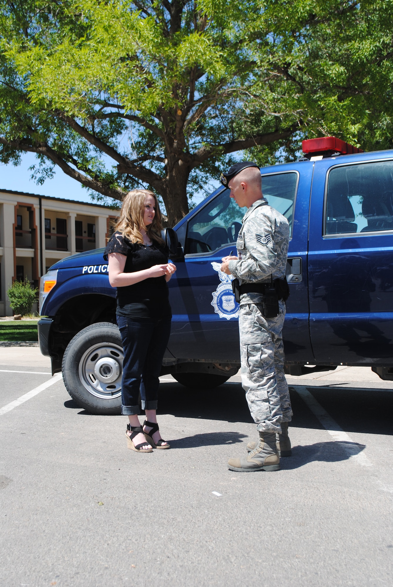 Staff Sgt. Richard Olsen, 377th Security Forces Squadron, takes a statement from Trisha Hardin in a photo reenactment. Hardin, a military spouse, was recently vigilant in notifying security forces when she noticed a woman in need. (Photo by Adam Bailey)