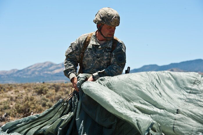 U.S. Army Col. Michael Fenzel, 82nd Airborne Division 3rd Brigade Combat Team commander, packs his parachute following an air-to-ground jump May 31, 2013, during the Joint Forcible Entry Exercise on the Nevada Test and Training Range, Nev. The exercise is the U.S. Air Force Weapons School biannual collaboration that, according to an Air Force fact sheet, exercises the Air Force's ability to tactically deliver and recover combat forces via air drops and combat landings in a contested environment. (U.S. Air Force photo by Staff Sgt. Michael Charles)