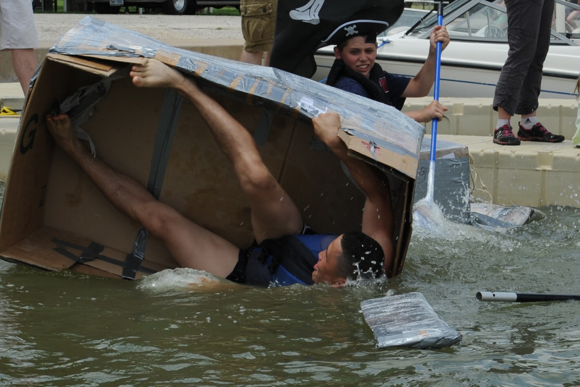 GOODFELLOW AIR FORCE BASE, Texas -- Team Z captain, Airman 1st Class Aziz Sarbashev, 17th Force Support Squadron, capsizes during the Build a Boat contest at the Goodfellow Recreation Camp, May 27. The goal of the competition is to sail a homemade boat out around a distance buoy and back again. (U.S. Air Force photo/ Staff Sgt. Laura R. McFarlane)