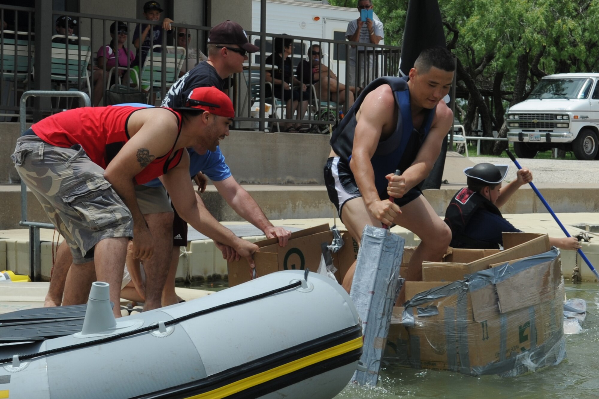 GOODFELLOW AIR FORCE BASE, Texas -- Competitors push off from a dock during the Build a Boat contest at the Goodfellow Recreation Camp, May 27. The two categories of the competition were individual and squadron. (U.S. Air Force photo/ Staff Sgt. Laura R. McFarlane)