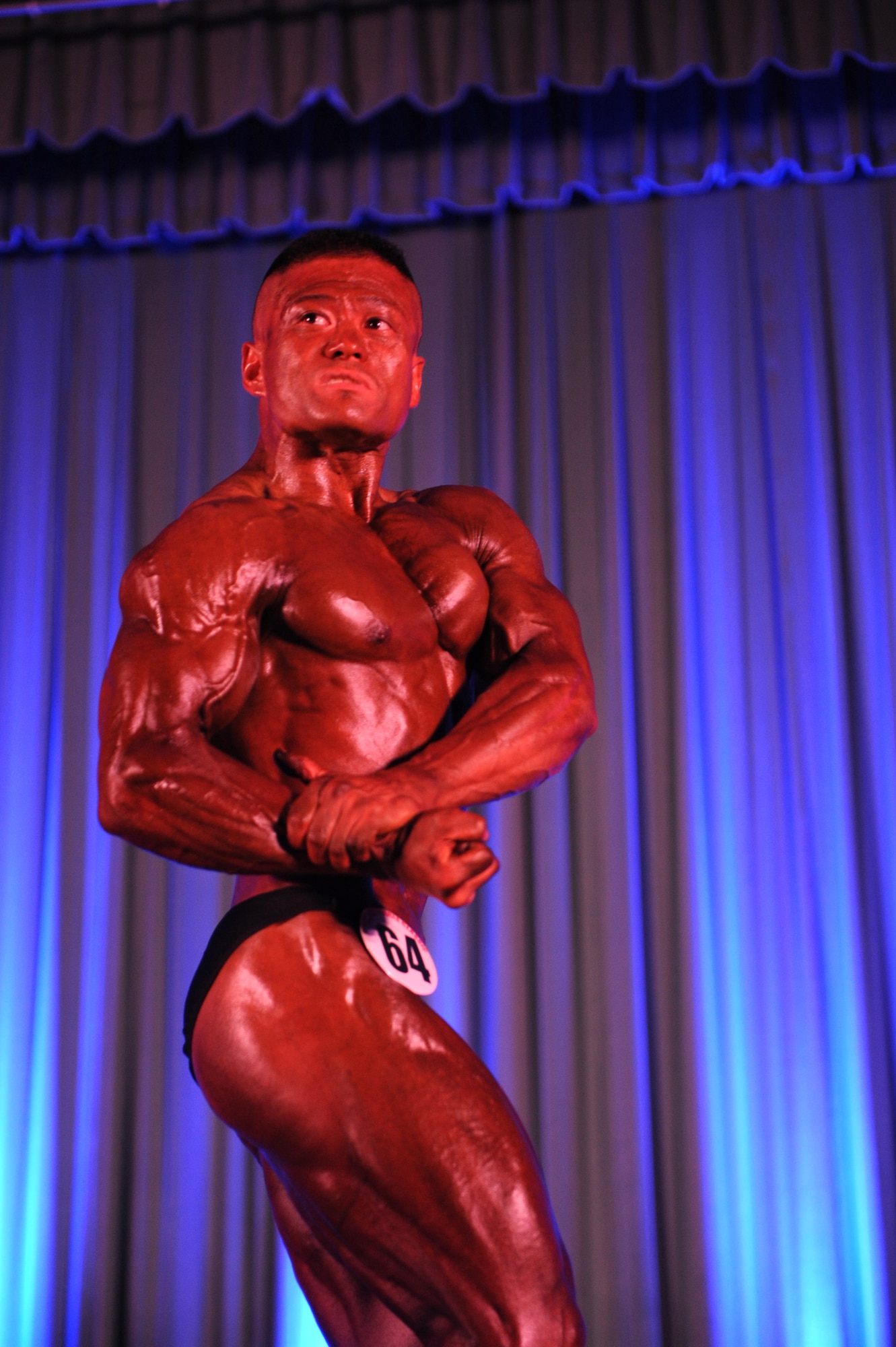 Shingo Nagato, 2013 Pacific Muscle Classic competitor, poses for the judges at the event at the Keystone Theater on Kadena Air Base, Japan, June 2, 2013. Nagato took home many awards, including first place in the men's masters over 40 category, first place in the male bodybuilders lightweight category and the overall male bodybuilders award. (U.S. Air Force photo by Airman 1st Class Hailey R. Davis/Released)