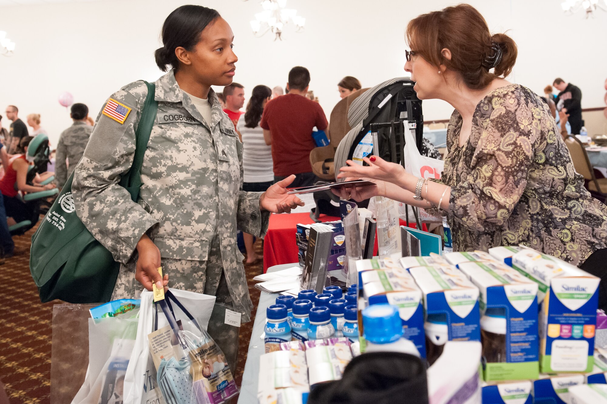 Sgt. Amber Cogborn, 244th Aviation Brigade fuel supply specialist, receives information from Millie Mardones, Abbott Nutrition Territory manager May 30, 2013, during the Baby Toddler Expo at Tommy B's Community Activities Center on Joint Base Mcguire-Dix-Lakehurst, N.J. The Family Advocacy team orchestrated the event that supported more than 261 families with 55 exhibitors from on base and the surrounding community. Cogborn hails from Detroit, Mich. (U.S. Air Force photo by Russ Meseroll/Released)