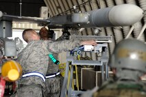 Staff Sgt. Gregory Harrison, left, and Airman 1st Class Jonathan Mahlan, middle, 8th Aircraft Maintenance Squadron, guide a missile onto an F-16 Fighting Falcon during an Operational Readiness Inspection at Kunsan Air Base, Republic of Korea, April 8, 2013. The ORI is tested the wing’s readiness and adherence to standards. (U.S. Air Force photo by Senior Airman Marcus Morris/Released)