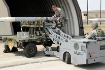 Staff Sgt. Gregory Harrison, 8th Aircraft Maintenance Squadron, guides Senior Airman Jade Call, 8th AMXS, as he lines up a bomb loader to a missile during an Operational Readiness Inspection at Kunsan Air Base, Republic of Korea, April 8, 2013. The Airmen prepared an F-16 Fighting Falcon for the first set of take-offs during the exercise assessing the readiness of the base. (U.S. Air Force photo by Senior Airman Marcus Morris/Released) 