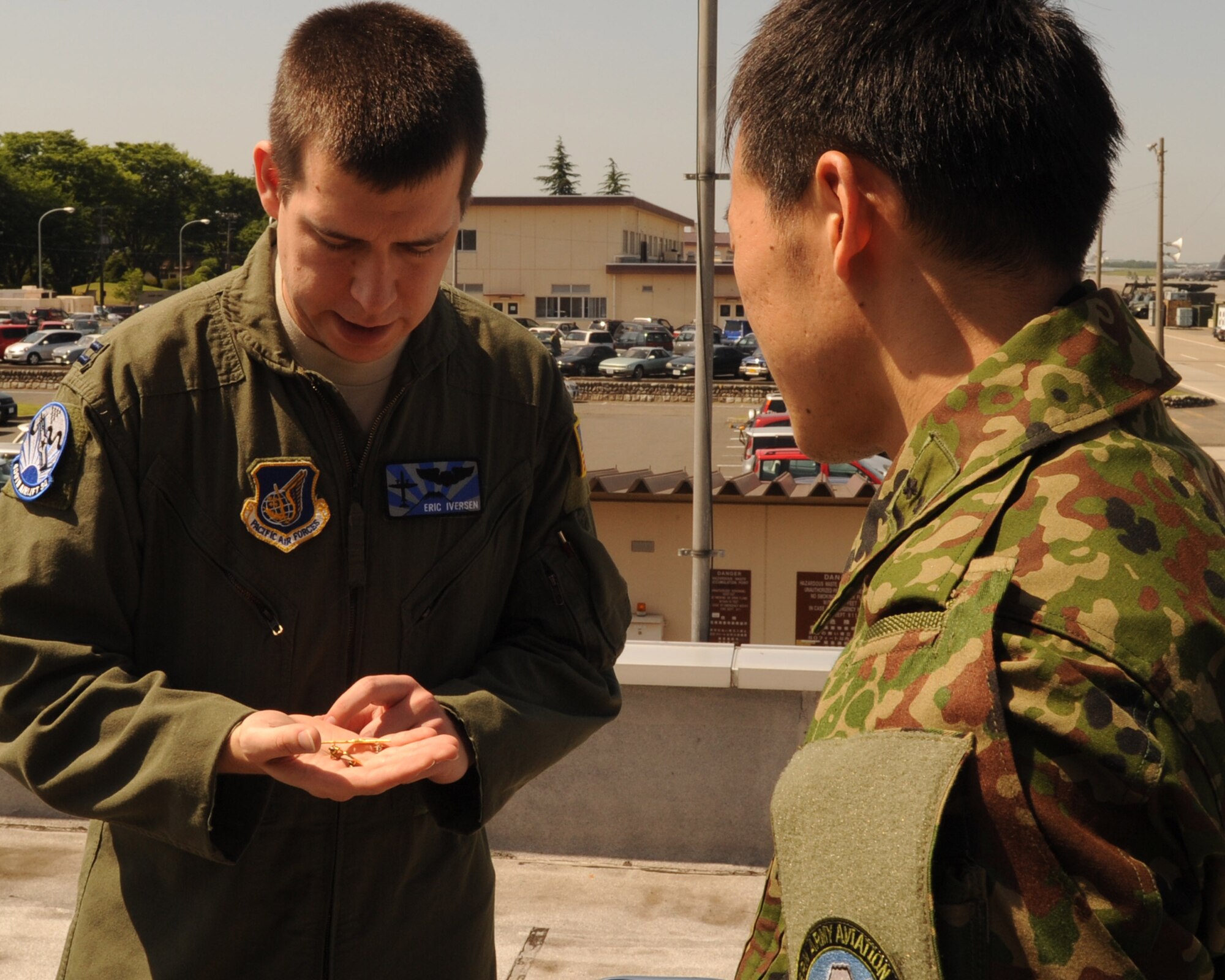YOKOTA AIR BASE, Japan – Capt. Eric Iversen (left), a pilot assigned to the 459th Airlift Squadron, talks with a member of the Japan Ground Self-Defense Force May 31, 2013, at Yokota Air Base, Japan. Members of the JGSDF assigned to Tachikawa Air Base visited Yokota in an effort to expand operational understanding and strengthen relationships between the two allies. (U.S. Air Force photo by Senior Airman Desiree Economides)