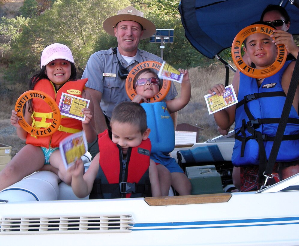 Park ranger Adam Thompson presents young boaters with "You've Been Caught Being Good" ice cream vouchers for wearing their life jackets as their families prepare to launch their boat at Pine Flat Lake, the U.S. Army Corps of Engineers Sacramento District park near Piedra, Calif.
