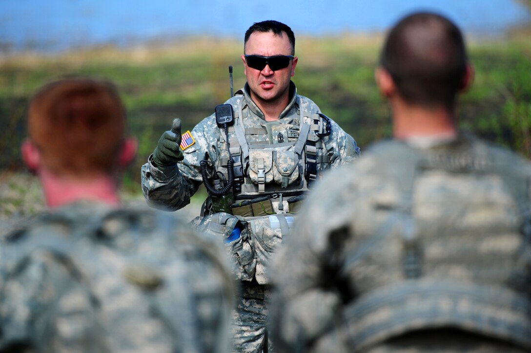 Army 1st Sgt. Timothy Pennartz, center, conducts an after-action review after a live-fire and movement-to-contact training exercise on an infantry squad battle course on Joint Base Elmendorf-Richardson, Alaska, May 31, 2013. Pennartz is assigned to Company A, 3rd Battalion, Airborne, 509th Infantry Regiment.