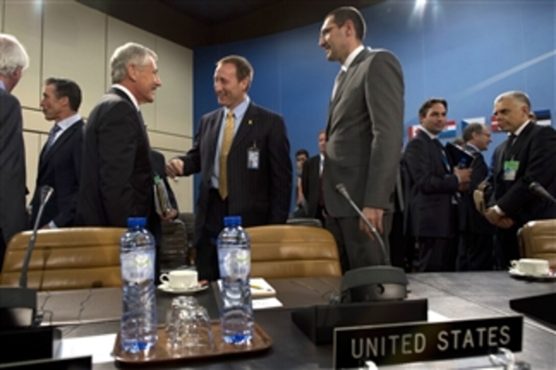 Secretary of Defense Chuck Hagel, third from left, greets Canadian Minister of National Defense Peter MacKay, center, at the beginning of a meeting of the North Atlantic Council at NATO headquarters in Brussels, Belgium, on June 4, 2013. NATO defense ministers will discuss topics including Afghanistan, cyber security, a possible Libya training mission and collective defense.  