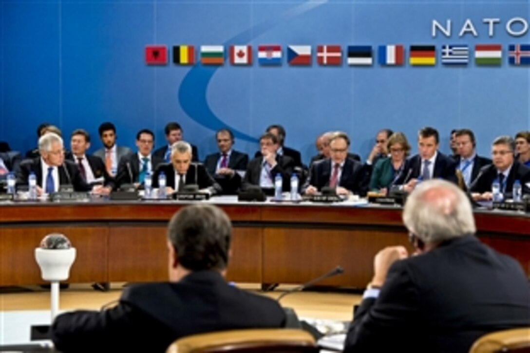 U.S. Defense Secretary Chuck Hagel, far left, listens as NATO Secretary General Anders Fogh Rasmussen delivers his opening statement during a meeting of the North Atlantic Council at NATO headquarters in Brussels, June 4, 2013. NATO defense ministers attending the meeting will address several topics, including Afghanistan, cybersecurity, a possible Libya training mission and collective defense.
