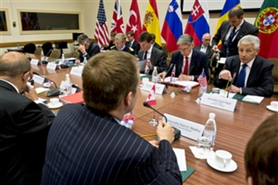 U.S. Defense Secretary Chuck Hagel, right, meets with British Defense Secretary Philip Hammond, second from right, Canadian Defense Minister Peter MacKay, right foreground, and French Defense Minister Jean-Yves Le Drian, left foreground, after a meeting of the North Atlantic Council at NATO in Brussels, June 4, 2013.