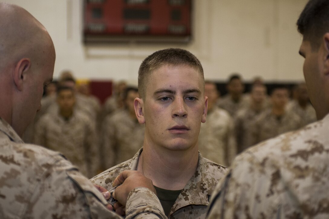 Cpl. Zachary Everett, noncommissioned officer in charge of maintaining the parade field at Marine Barracks Washington, D.C., gets promoted to the rank of corporal in the U.S. Marine Corps, June 3. (Official Marine Corps photo by Lance Cpl. Dan Hosack)