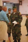 Derik Hernandez (right), a member of the Young Marines program, shakes hands with Sgt. Maj. Michael D. Johns (left), the sergeant major of Headquarters Battalion, 2nd Marine Division, after receiving his graduation certificate during the class’ graduation aboard Camp Lejeune, N.C., June 1, 2013. Hernandez’s father, a mobile logistics chief with Combat Logistics Regiment 2, 2nd Marine Logistics Group, watched the graduation ceremony from Afghanistan through a live video connection. 