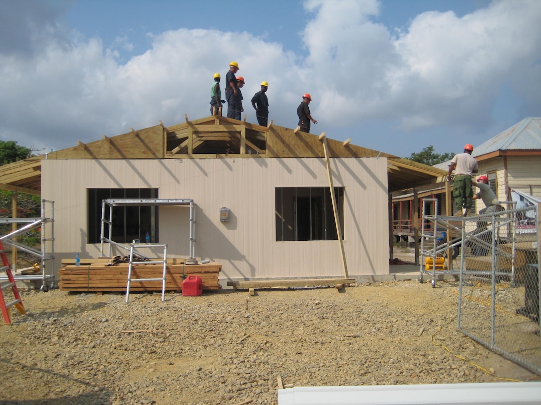 Belize Defense Force personnel perform construction on the roof of a new school in Crooked Tree, Belize in conjunction with their U.S. counterparts.  A joint force including U.S. Marine Corps combat engineers from Marine Wing Support Squadrons 471 and 472 built four schools during exercise New Horizons 2013.  New Horizons is a U.S. Southern Command exercise that gives U.S., Canadian and Belizean personnel an opportunity to train together in order to better meet future challenges. Personnel are providing medical and dental care, as well as constructing four educational buildings throughout Belize as part of the training. (Official U.S. Marine Corps photo: Courtesy photo//Released)