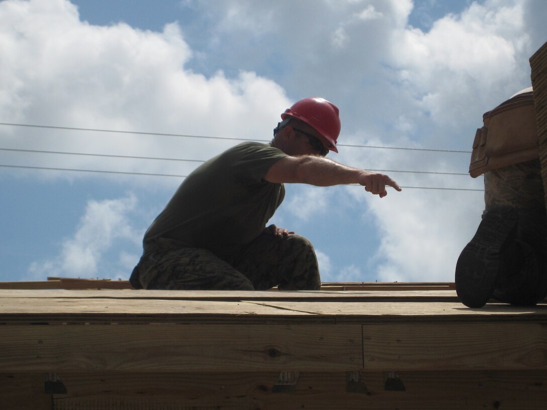 Sergeant Chris Johnson, a squad leader with Combat Engineer Platoon, Detachment B, Marine Wing Support Squadron 472, assists an airman with the 823rd Expeditionary RED HORSE Squadron in constructing the roof of a school in Ladyville, Belize during New Horizons 2013.  New Horizons is a U.S. Southern Command exercise that gives U.S., Canadian and Belizean personnel an opportunity to train together in order to better meet future challenges.  Personnel are providing medical and dental care, as well as constructing four educational buildings throughout Belize as part of the training.  (Official U.S. Marine Corps photo: Courtesy photo//Released)