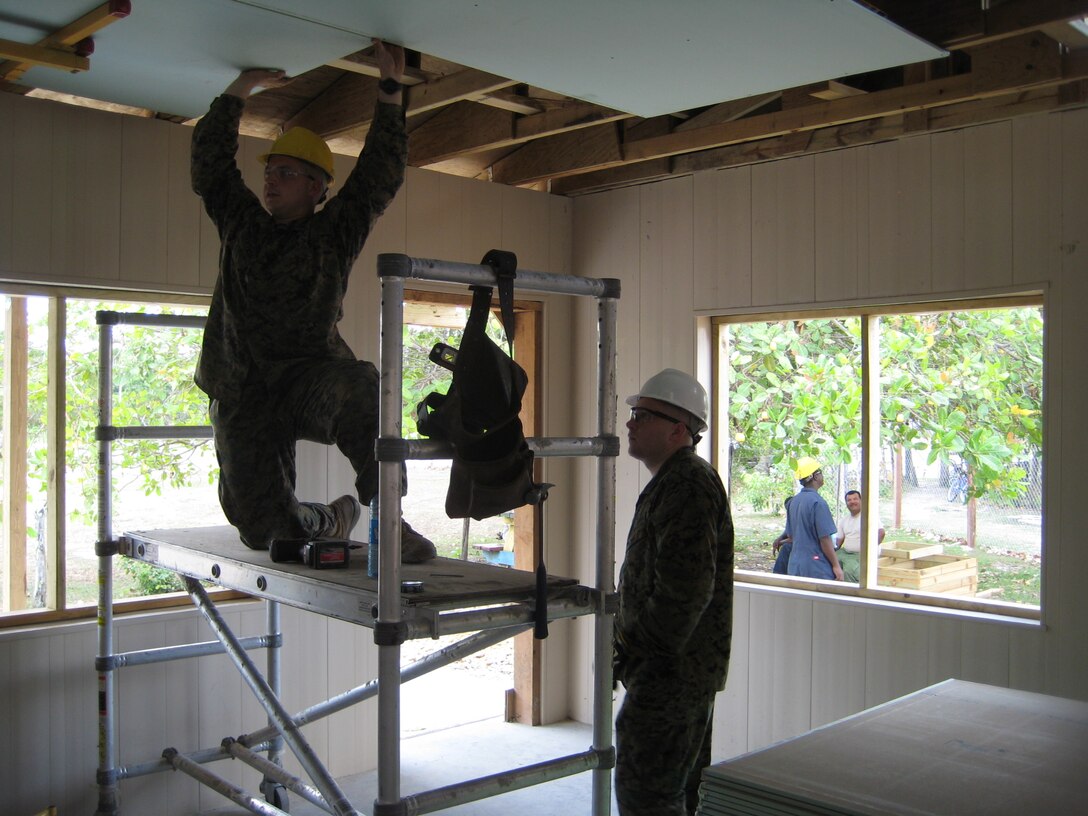 Gunnery Sgt. Robert Kendrick (right) and Lance Cpl. David Jerzewski, combat engineers with Marine Wing Support Squadron 471, Detachment B, hang drywall during ceiling construction efforts at a newly constructed school in Crooked Tree, Belize.  Kendrick and Jerzewski are reserve Marines who deployed to Belize to participate in New Horizons 2013. New Horizons is a U.S. Southern Command exercise that gives U.S., Canadian and Belizean personnel an opportunity to train together in order to better to meet future challenges. Personnel are providing medical and dental care, as well as constructing four educational buildings throughout Belize as part of the training.  (Official U.S. Marine Corps photo: Courtesy photo//Released)