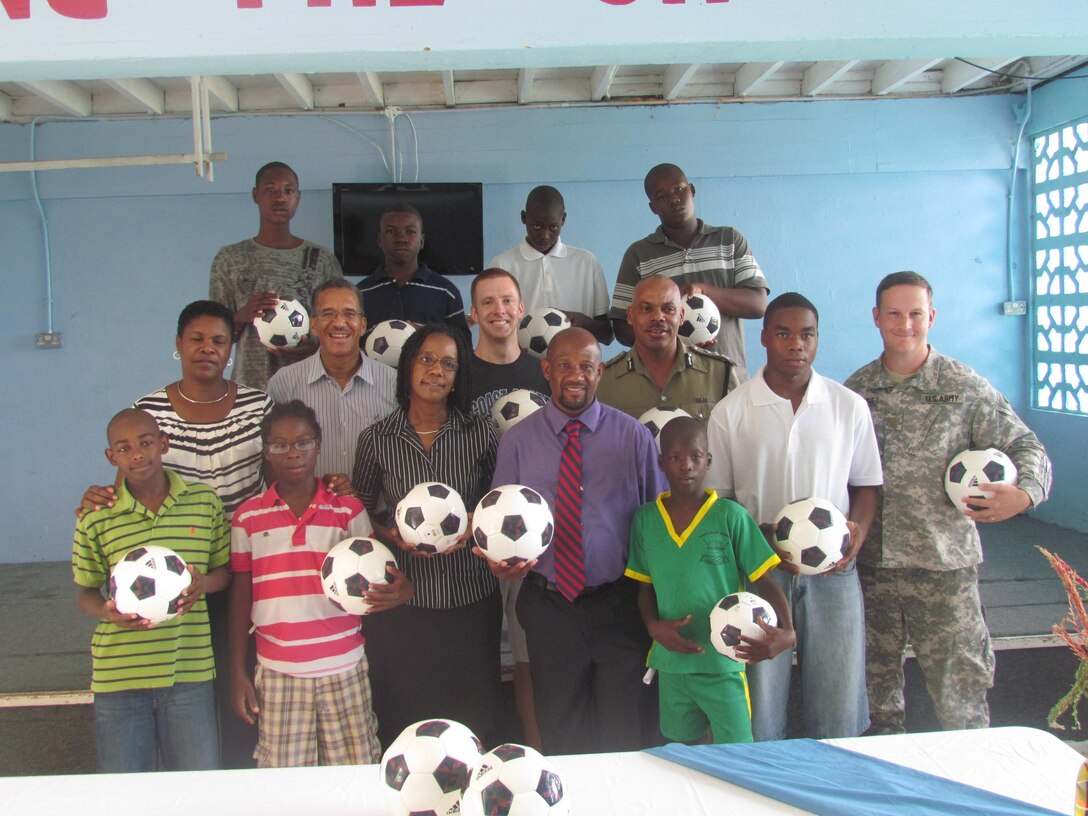Mr. Vernon Francois, the Commissioner of the Royal Saint Lucia Police Force and staff members and residents of the Boys Training Centre pose for a photo with representatives from the U.S. Embassy in Barbados, while holding new futbols presented by crewmembers of the U.S. Coast Guard Cutter Oak. The Boys Training Centre is sponsored by the USAID under the Juvenile Justice Reform Program. USAID’s Juvenile Justice Reform Program seeks to reduce recidivism rates among youth offenders and to increase the chances of youth who have had run-ins with the law to transform themselves into citizens who contribute positively to society. Tradewinds 2013 is a joint, combined exercise conducted in conjunction with partner nations to enhance the collective abilities of defense forces and constabularies to counter transnational organized crime and to conduct humanitarian/disaster relief operations. (Photo courtesy of Mr. Elvin Germain, The Boys Training Centre/Released)