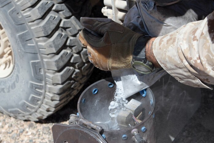 Sergeant Justin D. Wahlster, the training chief serving with Truck Company Alpha, Headquarters Battalion, 1st Marine Division, pours special effects powder into a metal canister as part of a simulated improvised explosive device here, May 3, 2013. When triggered, compressed air bursts into the canister, sending a cloud of harmless powder into the air to simulate an explosion. (U.S. Marine Corps photo by Sgt. Jacob H. Harrer)