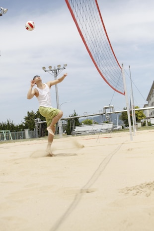 Lt. Alexander Cho, Marine Wing Support Squadron 171 chaplain, prepares to hit a volleyball during the Commander's Cup two-on-two volleyball tournament hosted by IronWorks intramural sports at the outdoor volleyball courts near IronWorks Gym at Marine Corps Air Station Iwakuni, Japan, May 17, 2013.