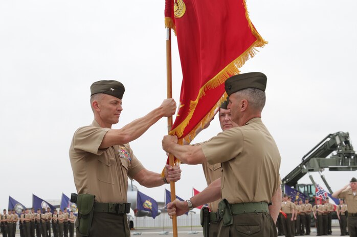 Col. Christopher J. Mahoney, former Marine Aircraft Group 12 commanding officer, passes the MAG-12 unit colors to Col. Hunter H. Hobson, the new MAG-12 commanding officer, during the MAG-12 change of command ceremony May 31, 2013. The morning of the ceremony, Col. Mahoney flew one last time in the Marine All Weather fighter Attack Squadron 242 flag ship with Col. Hobson flying by his side in a second aircraft.