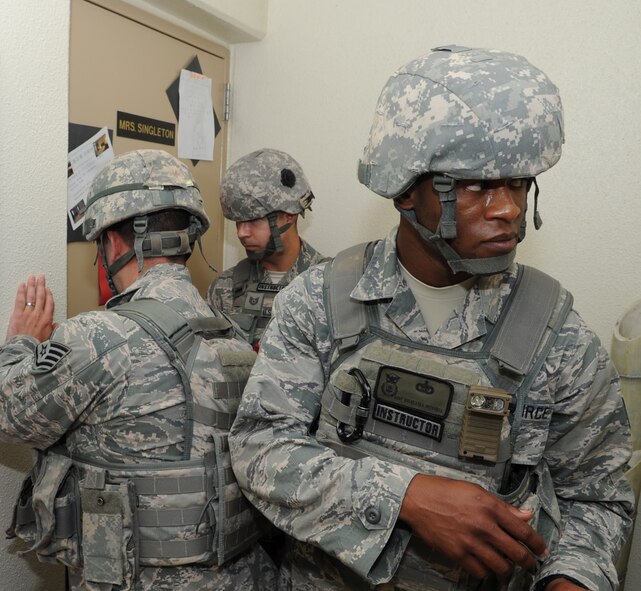 18th Security Forces Squadron members form up in a stack prior to entering a classroom at Kadena High School on Kadena Air Base, Japan, June 6, 2013. An active-shooter training scenario prompted the cops to perform a sweep of the campus to further check, secure and ensure the safety of students and personnel at the school in case of a real-world situation. (U.S. Air Force photo by Airman 1st Class Keith A. James/Released) 