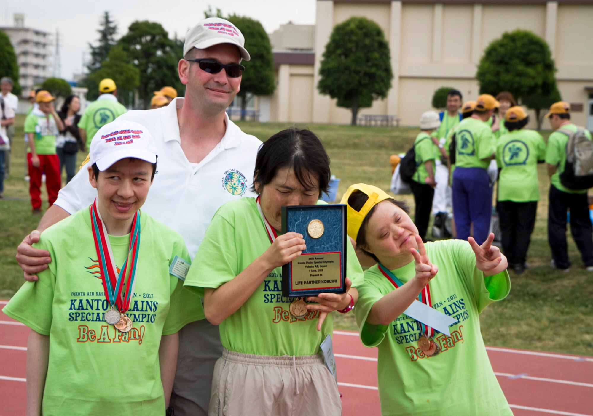 YOKOTA AIR BASE, Japan -- Special Olympics athletes and Master Sgt. Scott Hunkins, event director, pose for a picture after receiving metals during the Kanto Plains Special Olympics held at Yokota Air Base, Japan, June 1, 2013. Yokota hosted the event for more than 150 athletes from 10 local schools. (U.S. Air Force photo by Senior Airman William Johnson)