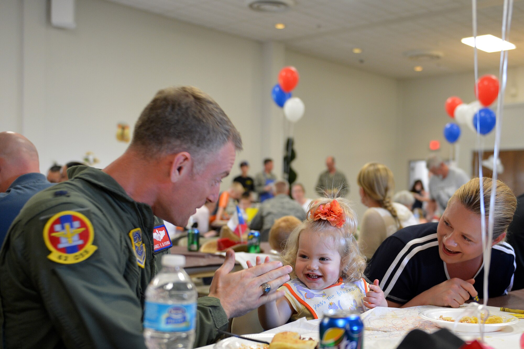 Lt. Col. Daniel Deyoung, 62nd Operations Support Squadron director of operations, plays with Emily Simmons June 3, 2013 during the quarterly deployed families dinner at Joint Base Lewis-McChord, Wash. Emily is the daughter of Lt. Col. Corey Simmons, 62nd OSS commander, who is currently deployed. (U.S. Air Force photo/Airman 1st Class Jacob Jimenez)