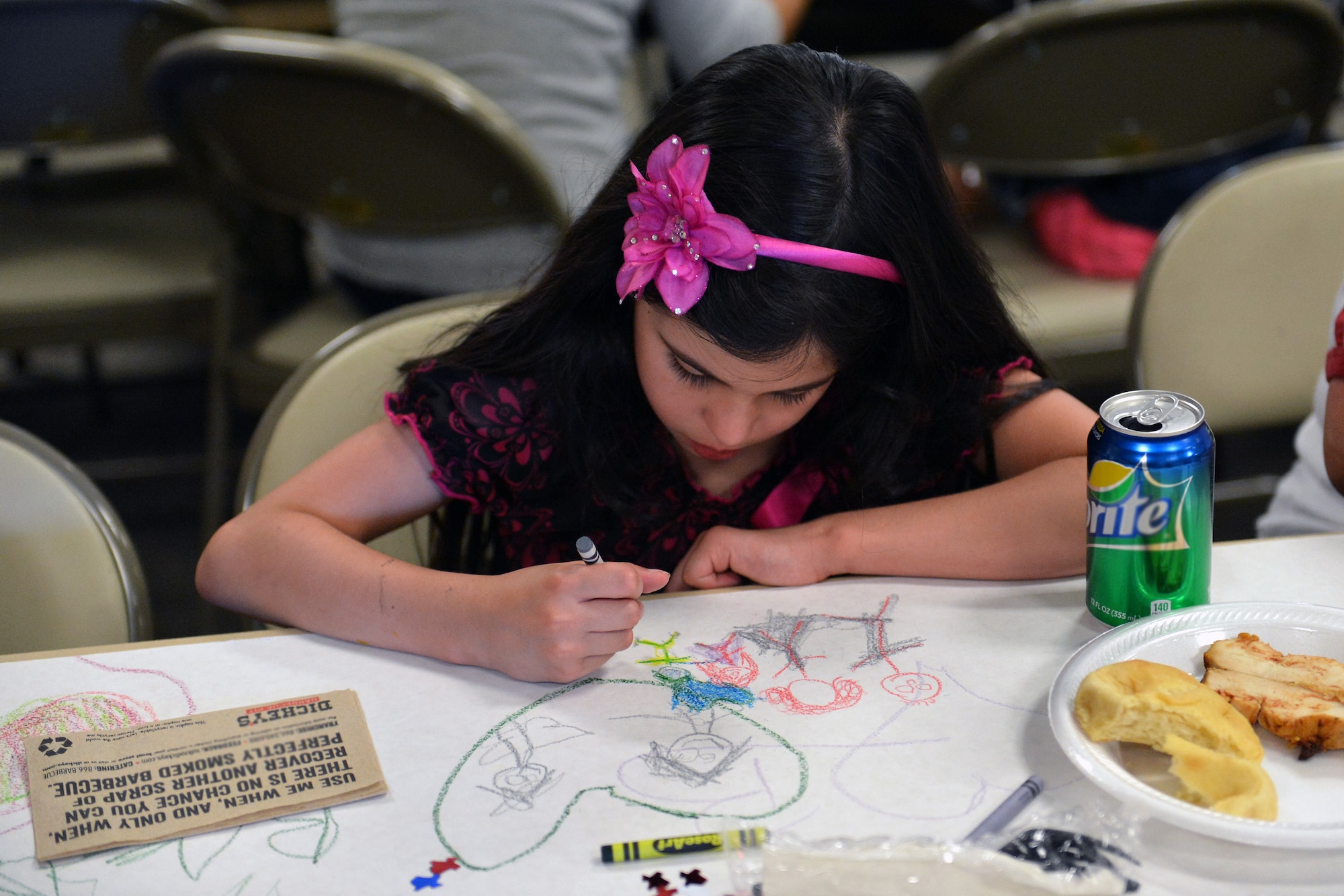 Brianna Cardenas draws a picture of her family, father, Master Sgt. Jose Cardenas and mother, Tracie, June 3, 2013 during the quarterly deployed families dinner at Joint Base Lewis-McChord, Wash. The event, free of charge to families of deployed servicemembers, included barbecue food, live band, bouncy house and raffle. (U.S. Air Force photo/Airman 1st Class Jacob Jimenez)