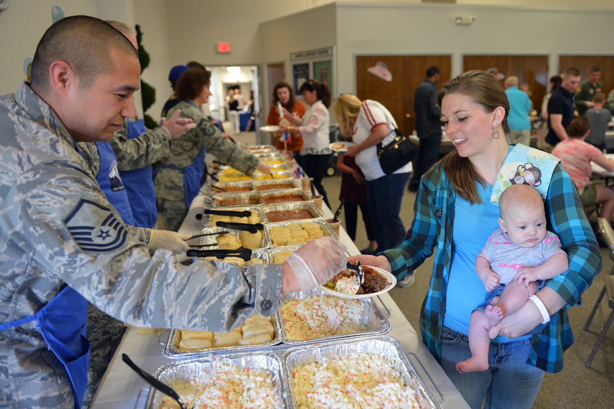 Master Sgt. Joseph Alvarez, 62nd Maintenance Squadron assistant first sergeant, serves coleslaw to Jacque Wray, spouse of Senior Airman Adam Wray, 62nd Aircraft Maintenance Squadron integrated flight controls systems specialist, June 3, 2013 during the quarterly deployed families dinner at Joint Base Lewis-McChord, Wash. The dinner was offered free of charge to families of deployed servicemembers and was sponsored by the base chapel, First Sergeants Club, Key Spouses Club and Military Spouses Club. (U.S. Air Force photo/Airman 1st Class Jacob Jimenez)