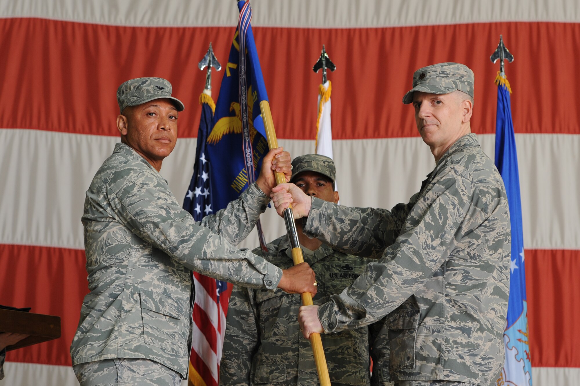 Col. Ray Lindsay, 8th Maintenance Group commander, accepts the guide-on from Maj. John Groff, 8th Maintenance Operations Squadron commander, during the 8th MOS deactivation ceremony at Kunsan Air Base, Republic of Korea, May 31, 2013. Airmen from the 8th MOS were transferred to various other squadrons within the 8th MXG. (U.S. Air Force photo by Staff Sgt. Jonathan Fowler/Released)