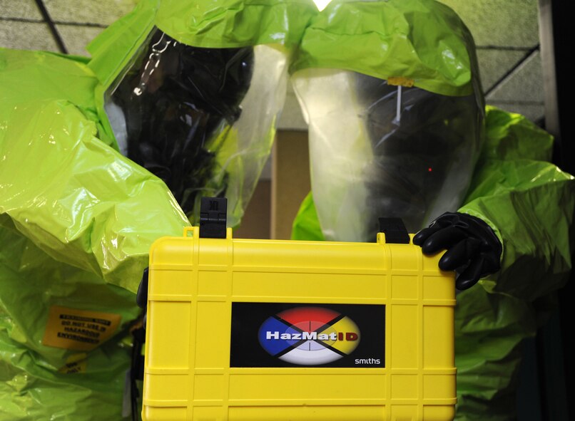 Col. Darren James, left, the 71st Flying Training Wing commander, and Staff Sgt. Travis DePrinzio, 71st Logistics Readiness Squadron, secure an unidentified brownish-white powder discovered in the base auditorium during a chemical-threat exercise held June 3 at Vance Air Force Base, Okla. (U.S. Air Force photo/ Senior Airman Frank Casciotta)