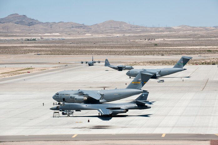 Several U.S. Air Force C-17 Globemaster IIIs, C-130 Hercules, and a B-1 Lancer Bomber aircraft park on the Nellis Air Force Base flightline May 31, 2013.  The C-17s and C-130s participated in the Joint Forcible Entry exercise, which practiced air dropping personnel and equipment in a contested environment. (U.S. Air Force Photo by Caitlin Kenney)