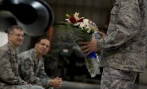 MINOT AIR FORCE BASE, N.D. – Maj. Aaron Rivers, 5th Maintenance Operations Squadron outgoing commander, presents his spouse and children with flowers and gifts during the 5th MOS inactivation ceremony, May 31. Members of these flights will now be directly responsible to the 5th Maintenance Group for the administration, analysis, training management, and programs and resources necessary to support the group production effort. All functions within the flights are expected to remain the same. (U.S. Air Force photos/Senior Airman Brittany Y. Auld)