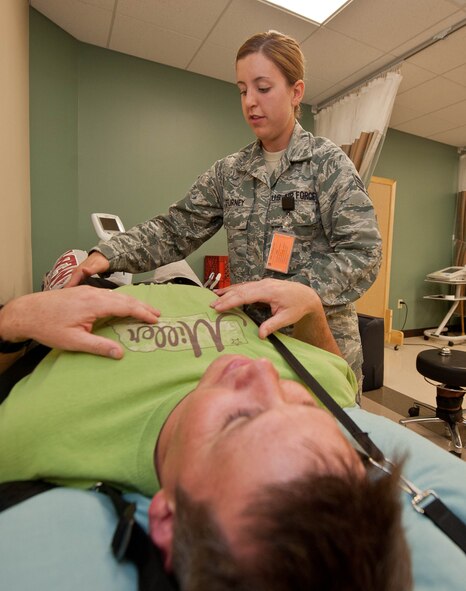 Senior Airman Haylley Turney, 28th Medical Operations Squadron physical medicine technician, hooks a traction machine up to Master Sgt. Shawn Savage, 28th Munitions Squadron assistant armament flight chief, to help build his lower back and leg muscles in the physical therapy clinic at Ellsworth Air Force Base, S.D., May 30, 2013. Physical medicine specialists help Airmen perform exercises designed to help them recover from muscle and bone injuries. (U.S. Air Force photo by Airman 1st Class Zachary Hada/Released)