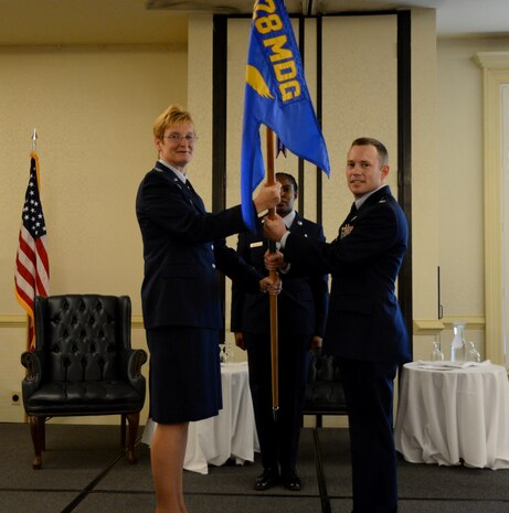 Col. Judith Hughes, 628th Medical Group commander, passes the squadron guidon to Lt. Col. Raymond Clydesdale, incoming 628th Aerospace Medicine Squadron commander, during the 628th AMDS  change of command ceremony June 3, 2013, at Joint Base Charleston – Air Base, S.C. (U.S. Air Force photo/Airman 1st Class Jasmonet Jackson) 