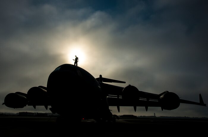 Tech. Sgt. Andrew Gravett, 437th Aircraft Maintenance Squadron crew chief, walks along the top of a C-17 Globemaster III while wearing a safety harness as he does a routine maintenance check of the aircraft June 4, 2013, at Joint Base Charleston – Air Base, S.C. The first C-17 to enter the Air Force’s inventory arrived at Charleston Air Force Base in June 1993. The C-17 is capable of rapid strategic delivery of troops and all types of cargo to main operating bases or directly to forward bases in the deployment area. (U.S. Air Force photo/Senior Airman Dennis Sloan)