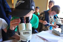 Zachary, a fourth grader from Michael Anderson Elementary School, looks through a microscope at an organism called the adult Backswimmer during the water study session May 31, 2013, at YMCA Camp Reed. Students had the opportunity to see many more aquatic organisms from the lake. (U.S. Air Force photo by Senior Airman Earlandez Young/Released)   