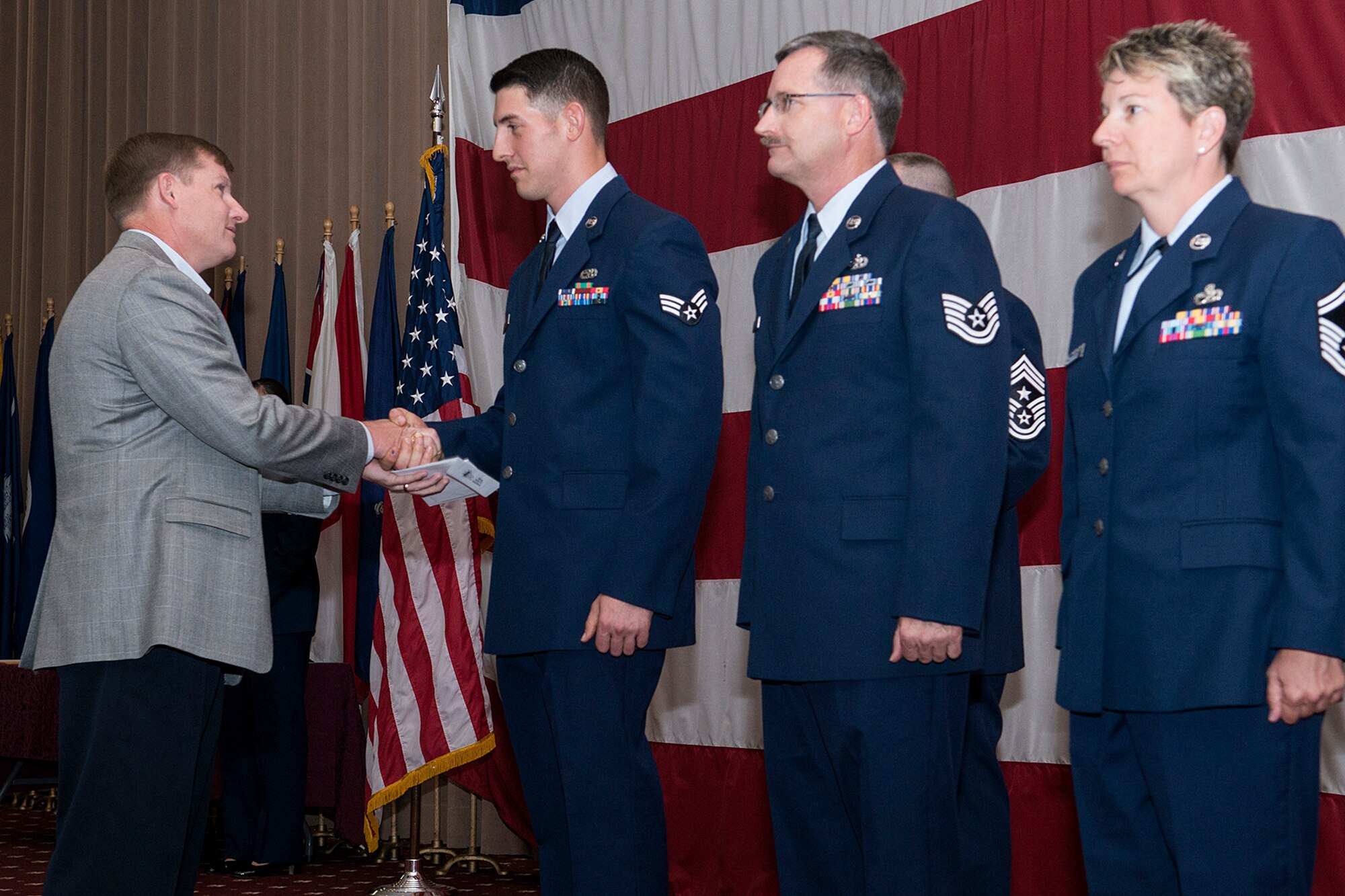 Retired U.S. Air Force Col. Andy Thomson, from the Bossier City Chamber of Commerce, presents gift certificates to Senior Airman Michael Custodio, who was selected as Airman of the Quarter, June 2, 2013, Barksdale Air Force Base, La. Also accepting awards is Tech. Sgt. Daniel Burns, Noncommissioned Officer of the Quarter,  and Senior Master Sgt. Lisa Vanderhoff, Senior Noncommissioned Officer of the Quarter. (U.S. Air Force photo by Master Sgt. Greg Steele/Released)