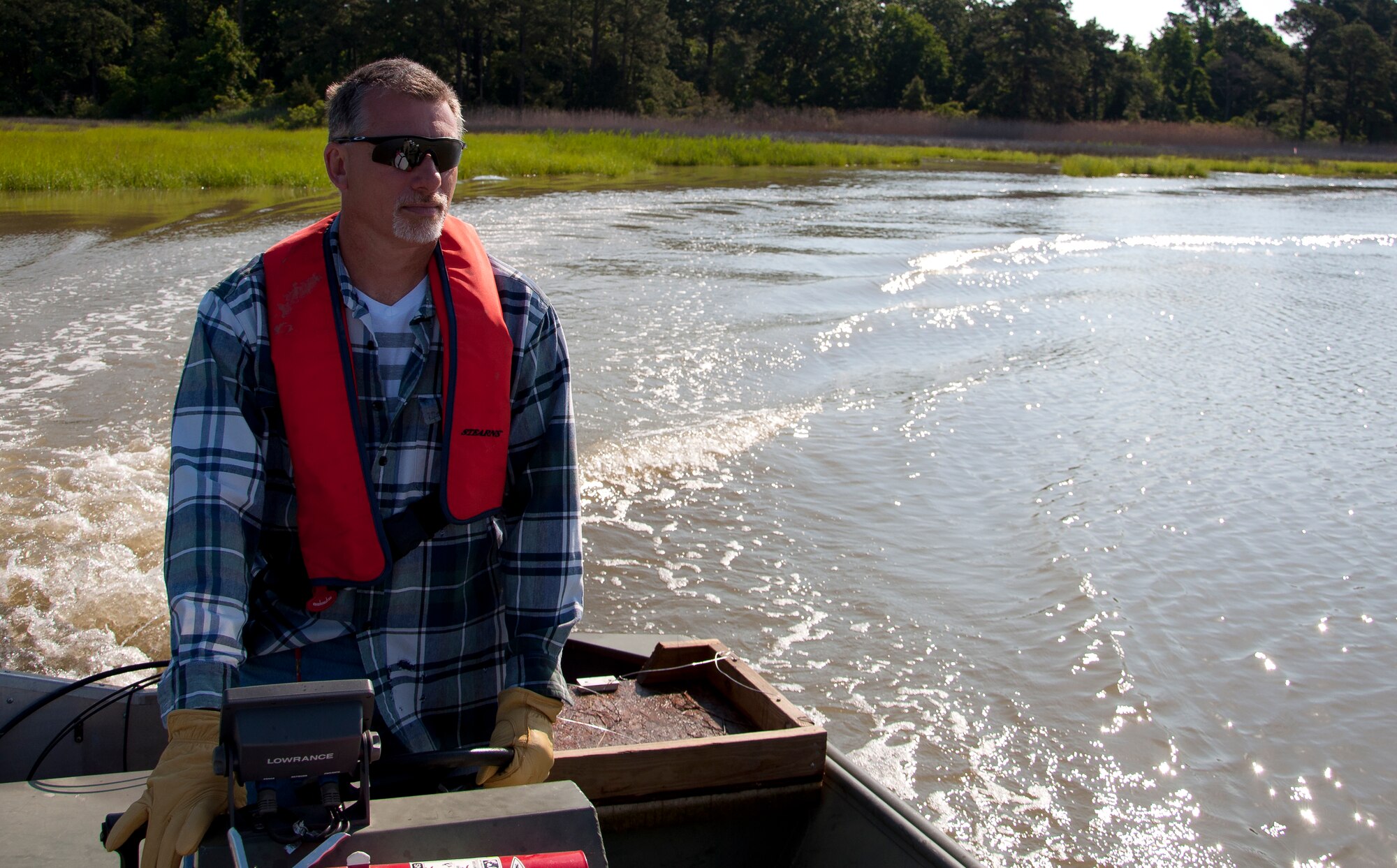 James Dolan, 733rd Civil Engineer Division environmental flight conservationist, maneuvers his boat through a small tributary of the James River in search of nutria signs at Fort Eustis, Va., June 4, 2013. Nutria are semi-aquatic creatures, so Dolan must place curiosity traps in locations reachable only by boat. (U.S. Air Force photo by Airman 1st Class Austin Harvill/Released)