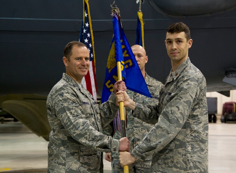 MINOT AIR FORCE BASE, N.D. -- Maj. Aaron Rivers (right), outgoing 5th Maintenance Operations Squadron commander hands the 5th MOS guidon to Col. Eric Froehlich, 5th Maintenance Group commander, during the inactivation ceremony of the 5th MOS, May 31. The 5th MOS was activated at Minot in 2002 following a reorganization of the then 5th Logistics Support Squadron. Since 2002, the squadron has earned two Air Force Outstanding Unit Awards. (U.S. Air Force photo/Senior Airman Brittany Y. Auld)
