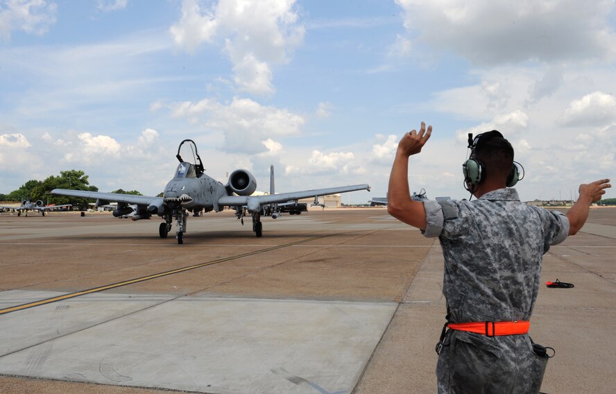 Senior Airman Jason Norris, a crew chief from Moody Air Force Base, Ga., guides an A-10 Thunderbolt II fighter into a parking space on Barksdale Air Force Base, La., June 4, 2013. The A-10 is equipped with one 30 mm GAU-8/A seven-barrel Gatling Gun capable of firing 3,900 rounds per minute to defeat a wide variety of targets including tanks. (U.S. Air Force photo/Airman 1st Class Benjamin Gonsier)