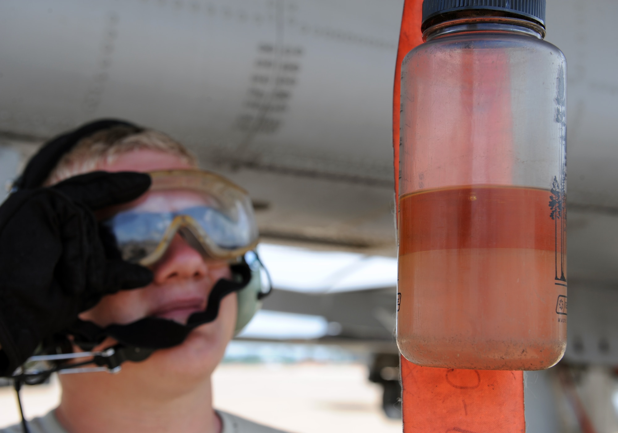 Airman 1st Class Steven Clennon, a crew chief from Moody Air Force Base, Ga., checks a bottle reclaiming fuel from an A-10 Thunderbolt II fighter on Barksdale Air Force Base, La., June 4, 2013. Airmen from Moody are participating in the exercise Green Flag East. The exercise trains Airmen from different career fields to work together and prepare for deployments to combat environments. (U.S. Air Force photo/Airman 1st Class Benjamin Gonsier)
