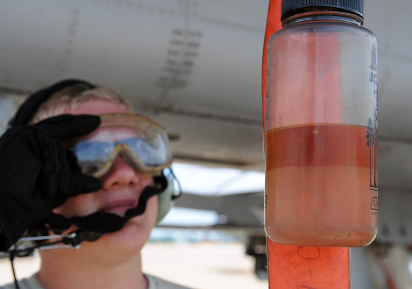 Airman 1st Class Steven Clennon, a crew chief from Moody Air Force Base, Ga., checks a bottle reclaiming fuel from an A-10 Thunderbolt II fighter on Barksdale Air Force Base, La., June 4, 2013. Airmen from Moody are participating in the exercise Green Flag East. The exercise trains Airmen from different career fields to work together and prepare for deployments to combat environments. (U.S. Air Force photo/Airman 1st Class Benjamin Gonsier)