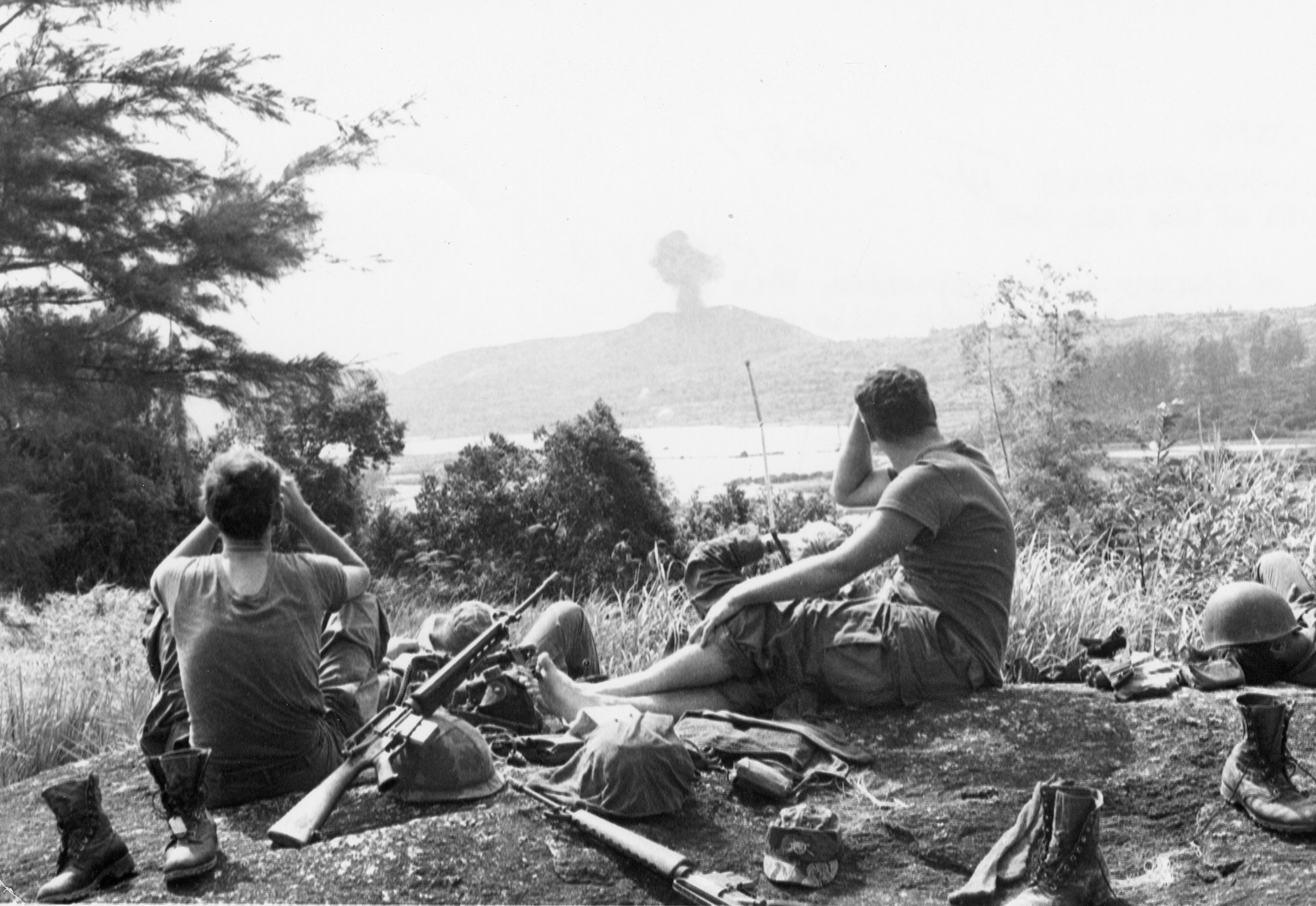 While taking a break during a combat sweep south of Chu Lai, South Vietnam, these U.S. Army soldiers watch air strikes pound suspected communist positions in November 1969. (U.S. Air Force photo)