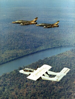 Nicknamed the “Hun,” the F-100 Super Sabre was possibly the best-known USAF close air support aircraft in the Southeast Asia War. Here, a forward air controller in an OV-10 directs these two F-100s in accurately delivering firepower in support of the ground forces. (U.S. Air Force photo)