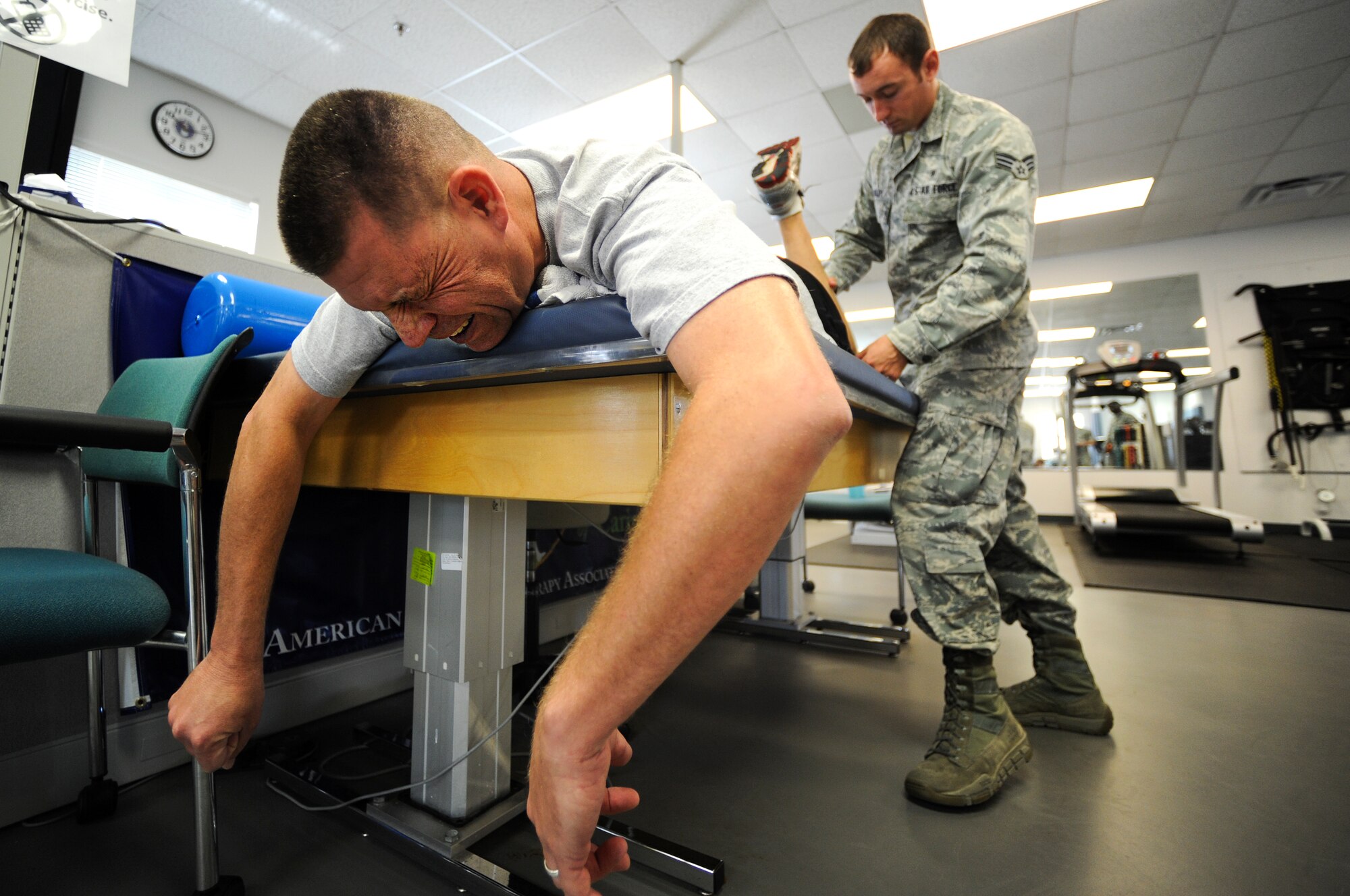 U.S. Air Force Master Sgt. David Desjardin, training management section chief for 1st Special Operations Maintenance Operations Squadron (left), gets assistance from Senior Airman David Curley, noncommissioned officer in charge of physical therapy for 1st Special Operations Medical Operations Squadron, with passive range of motion during physical training on Hurlburt Field, Fla., May 29, 2013. Physical training technicians are primarily concerned with the remediation of injuries and disabilities to promote mobility, functional ability, movement potential and quality of life. (U.S. Air Force photo/Airman 1st Class Christopher Callaway)