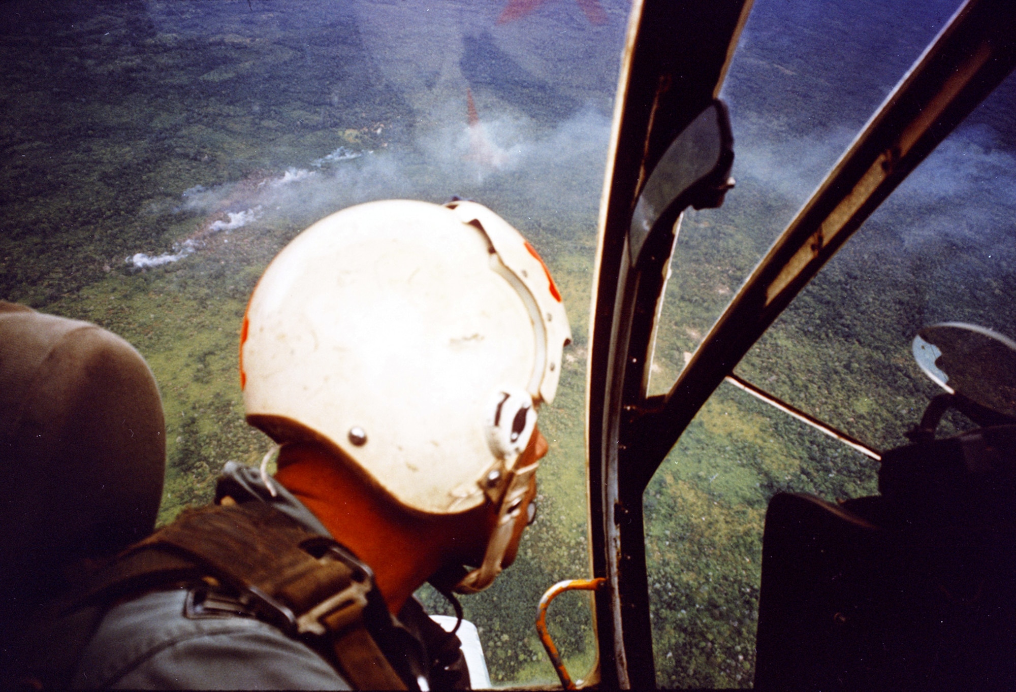 An American-trained South Vietnamese A-1E pilot looking at a target area after a close air strike against Viet Cong. (U.S. Air Force photo)