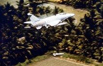 The pilot of this F-100 pulls up sharply after releasing a napalm bomb on Viet Cong concealed in the tree line in the Mekong Delta. (U.S. Air Force photo)